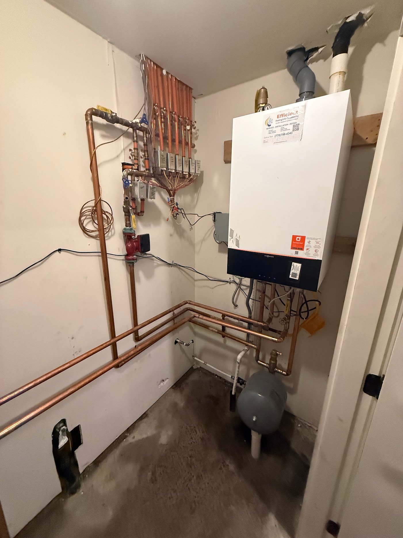 Boiler and external zone valves — heating circuit planning Wall-mounted Viessmann boiler beside copper heating circuits, external zone valves and a circulator