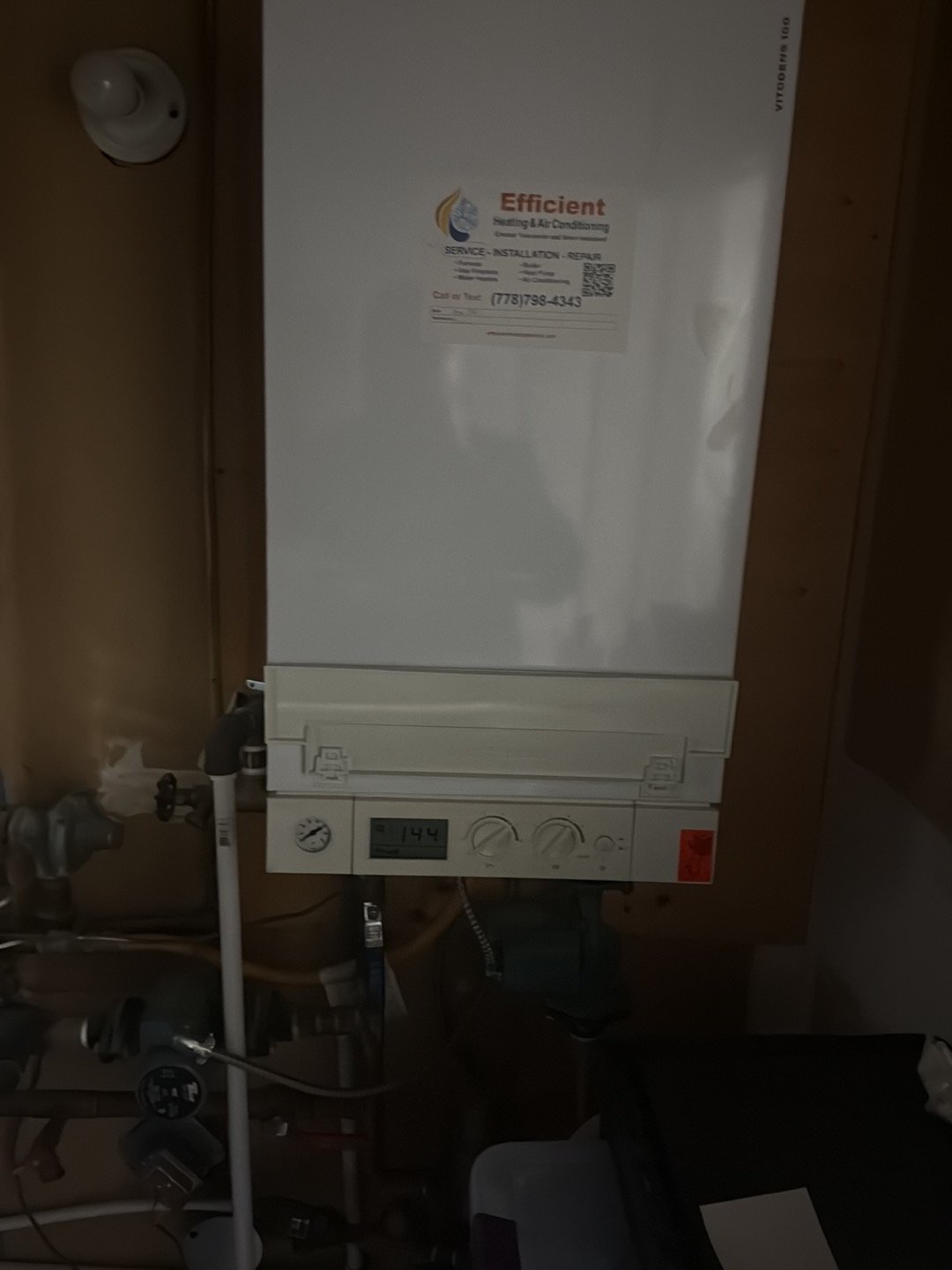 Existing Viessmann boiler — replacement assessment reference Wall-mounted Viessmann boiler with connected copper pipework and a circulator below the cabinet