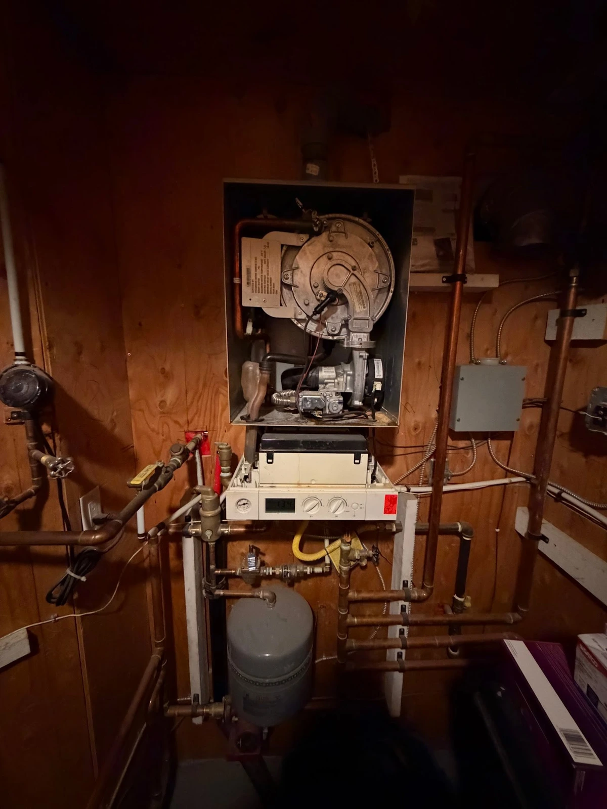 Boiler with its cover removed, internal components, pipework and expansion tank.