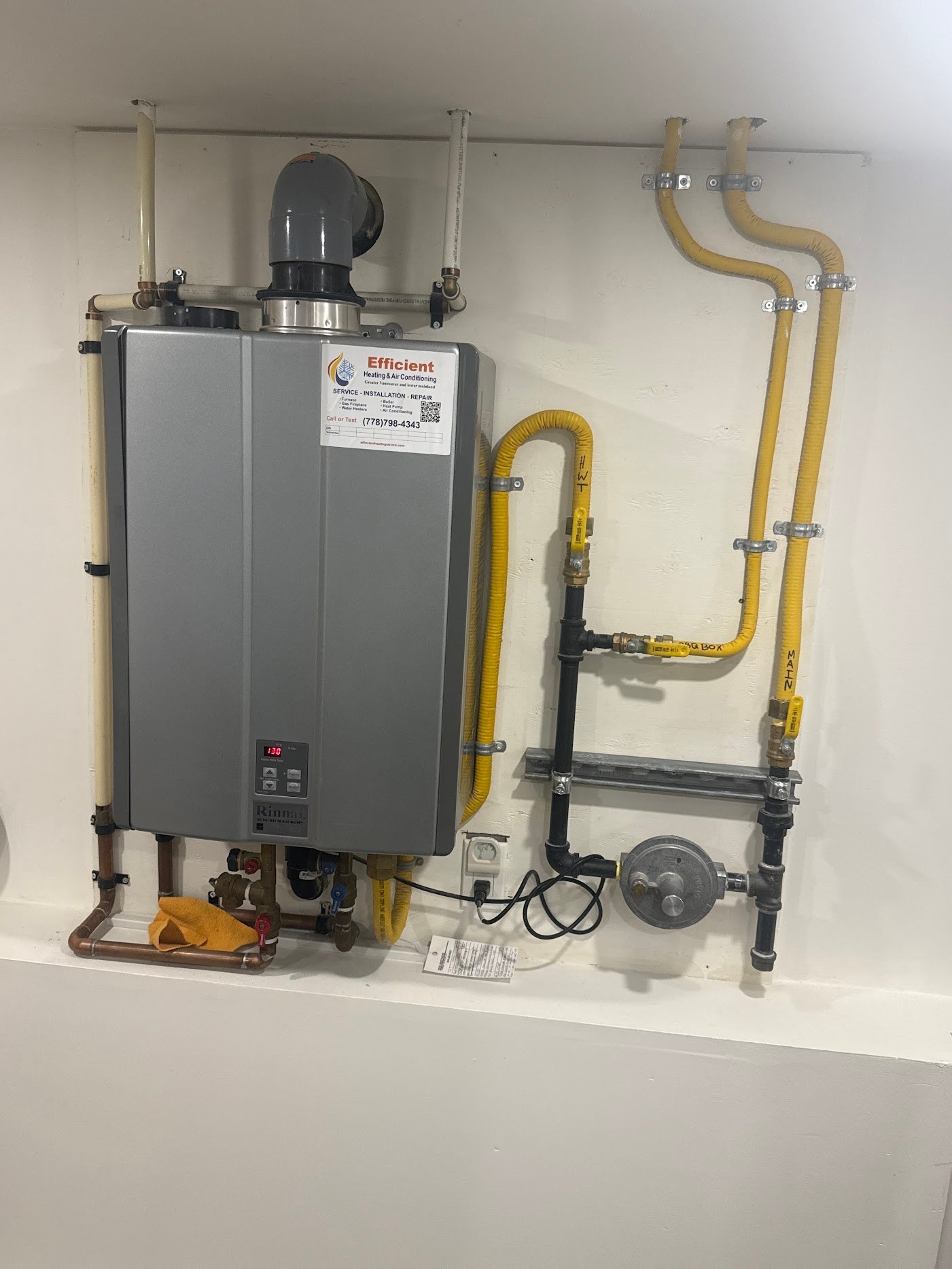 Wall-mounted boiler and gas piping in an Efficient Heating Service field photo